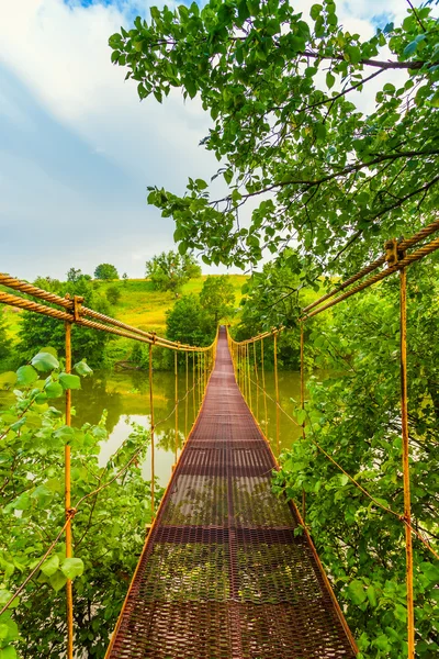 Ponte sospeso in metallo sul fiume — Foto Stock