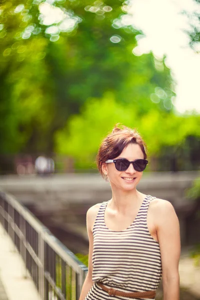 Fashion portrait of a young sexy woman wearing sunglasses with beauty bokeh — Stock Photo, Image
