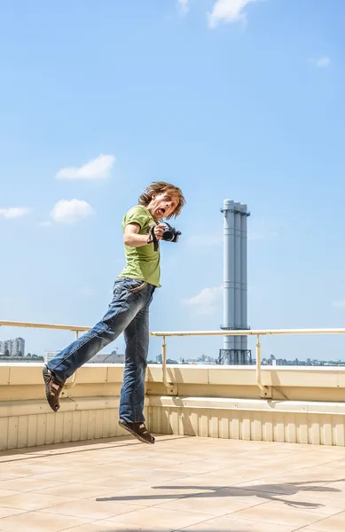 Crazy cheerful photographer in jump — Stock Photo, Image