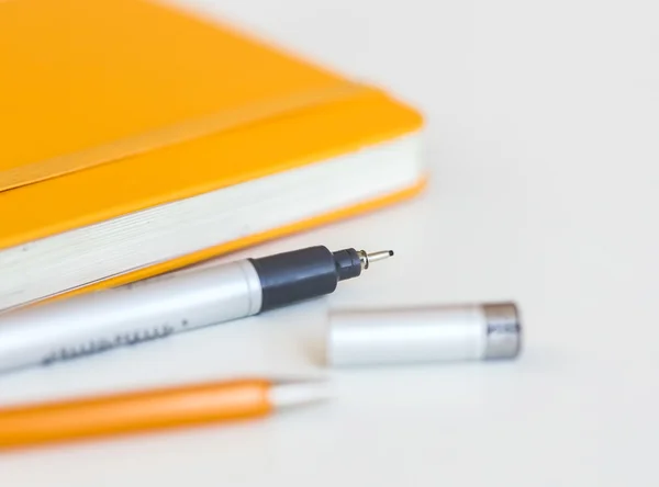 Cuaderno de cubierta amarillo con lápiz negro y pequeña profundidad de campo —  Fotos de Stock