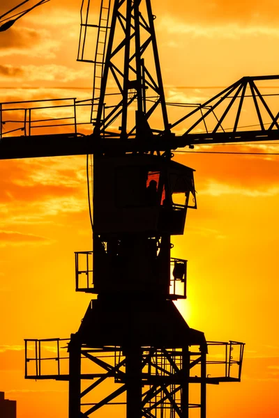 Silhouette gru costruzione industriale sopra il sole all'alba — Foto Stock