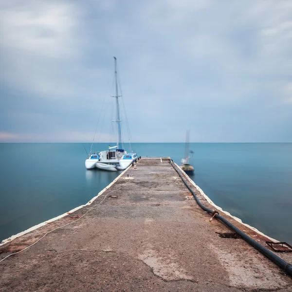 Paisaje marino minimalista. Barco en un muelle . — Foto de Stock