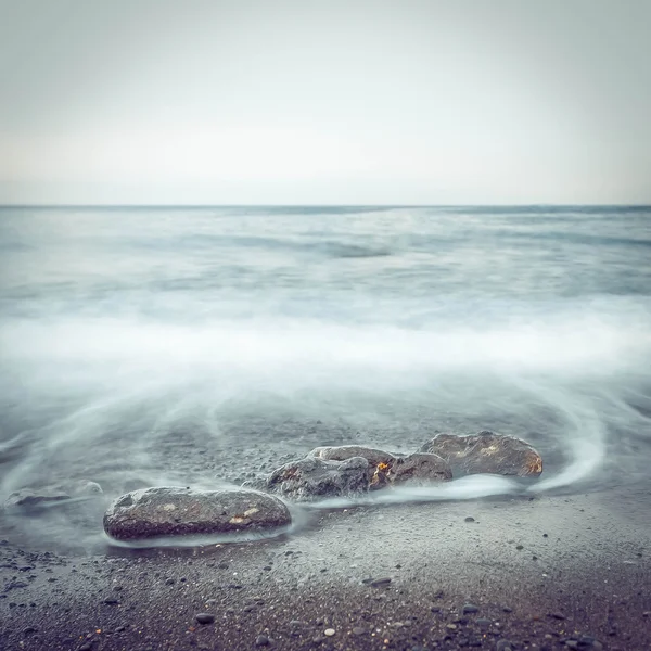 Kayaların uzun pozlama ile minimalist puslu deniz manzarası — Stok fotoğraf