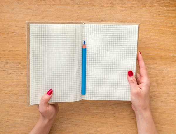Frauen halten ein neues Notizbuch auf Holzgrund in der Hand — Stockfoto