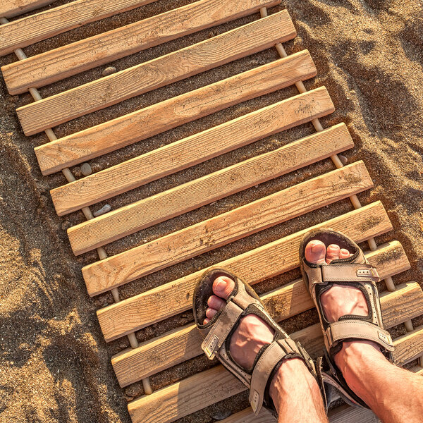 Man feet on beach sand