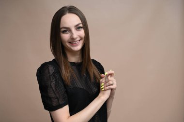 Mutlu esmer, stüdyoda kameraya bakıyor.