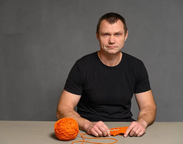 Portret Van Een Man Zittend Aan Een Tafel Breiend Met — Stockfoto