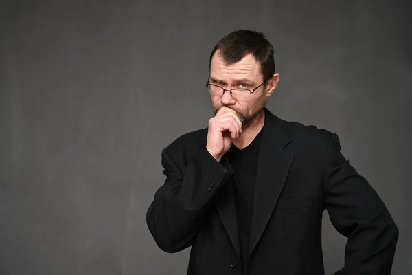 Adult Man Black Jacket Glasses Looks Camera Thoughtfully Gray Background Stock Image