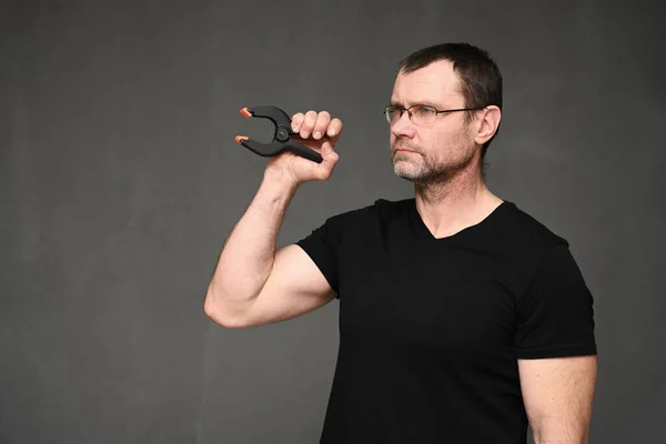 Retrato vista lateral de um homem sério em óculos segurando uma ferramenta em sua mão — Fotografia de Stock