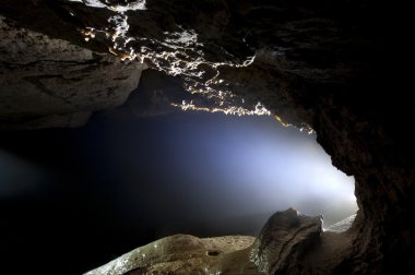 Light in a cave with limestone deposits clipart