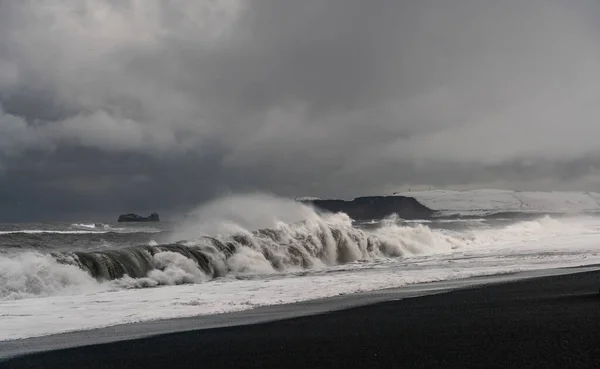 Stürmische Wellen am schwarzen Vulkanstrand in der Nähe der berühmten Reynisfjara-Felsen an der Südküste Islands — Stockfoto