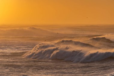 Reynisfjara Sahili 'ndeki Dyrholaey Burnu' ndan ve İzlanda 'daki Reynisdrangar bazalt deniz yığınlarından görüntüler. Fırtınalı gün doğumu