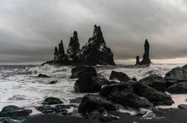 Bazalt kaya oluşumları siyah sahilde Trol ayak parmakları. Fırtınada Reynisdrangar, Vik, İzlanda