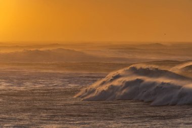 Reynisfjara Sahili 'ndeki Dyrholaey Burnu' ndan ve İzlanda 'daki Reynisdrangar bazalt deniz yığınlarından görüntüler. Fırtınalı gün doğumu