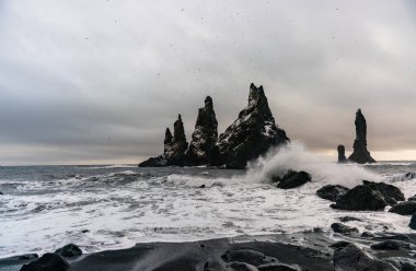 Bazalt kaya oluşumları siyah sahilde Trol ayak parmakları. Fırtınada Reynisdrangar, Vik, İzlanda
