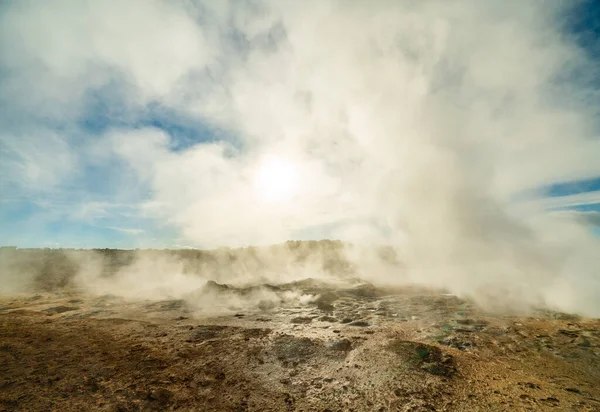 Геотермальна зона Намафьалл-Хверир в Ісландії. Дивовижний краєвид сірчаної долини з курінням фумаролів і блакитним хмарним небом, подорож фоном, туристична привабливість — стокове фото