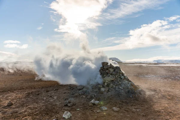 Геотермальная зона Намафьела Хверира в Исландии. Потрясающий пейзаж серной долины с дымящимися фумаролами и голубым облачным небом, туристический фон, туристическая достопримечательность — стоковое фото