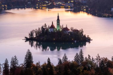 İkonik Göl, St. Marys Kilisesi ve dağlarla birlikte soğuk sonbahar sabahı göğü, Slovenya ve Avrupa 'ya karşı kanadı..