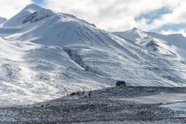 Karda dağların arasında terk edilmiş yapayalnız bir yapı. İzlanda 'da kış.