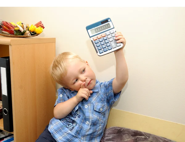 Cute boy in office with calculator — Stock Photo, Image