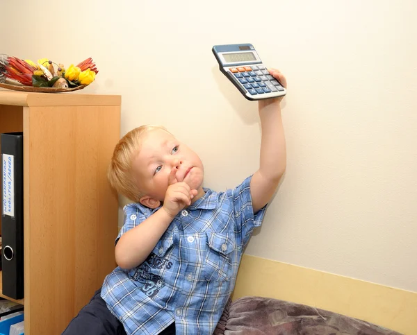 Cute boy in office with calculator — Stock Photo, Image