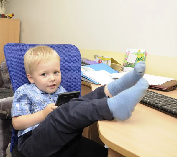 Cute boy in office with calculator — Stock Photo, Image