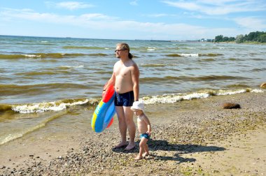 sevimli çocuk ve babası bir sahilde bir tekne kürek
