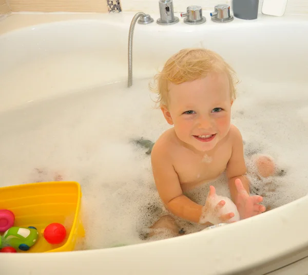 Gelukkig kind baadt in een badkamer — Stockfoto