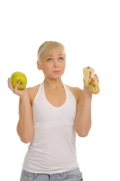 Тонкая женщина выбирает между яблоком и гамбургером — стоковое фото