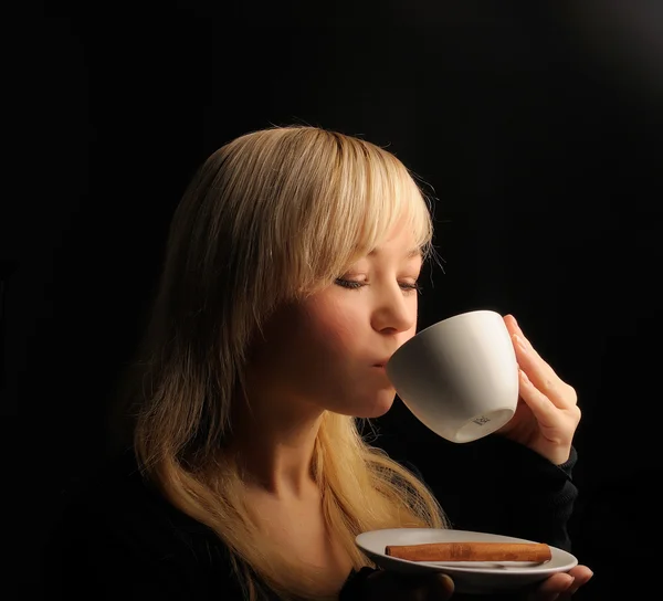 Νεαρό ξανθιά μαλλιά γυναίκα με καφέ σε σκούρο φόντο — Φωτογραφία Αρχείου