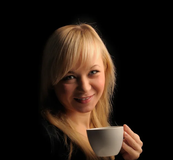 Junge Frau mit blonden Haaren mit Kaffee auf dunklem Hintergrund — Stockfoto