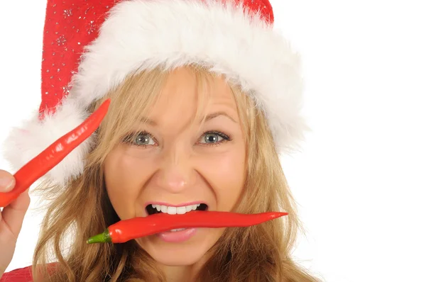 Attraktive junge Frau in Weihnachtsmannmütze mit Chilipfeffer. isoliert auf weiß — Stockfoto