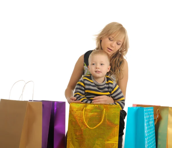 Schöne Frau und ihr Sohn nach dem Einkaufen. isoliert auf weiß — Stockfoto