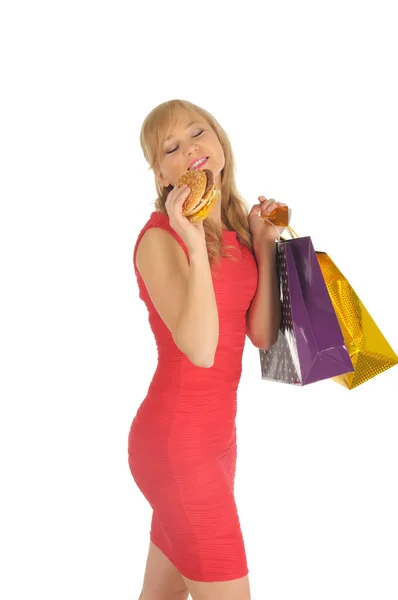 Молода красива жінка з торговими пакетами і гамбургер ізольовані на білому — стокове фото