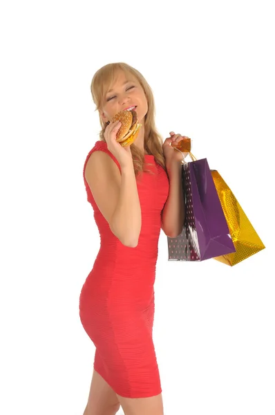 Jonge mooie vrouw met een aantal boodschappentassen en hamburger geïsoleerd op wit — Stockfoto