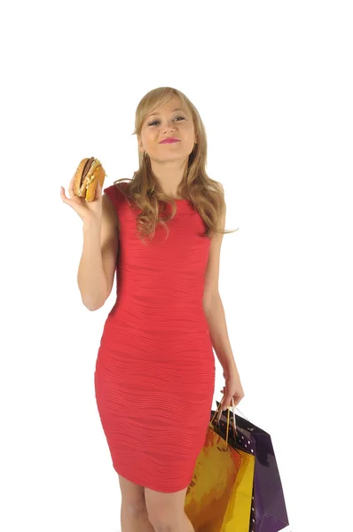 Ung vacker kvinna med några påsar och hamburgare isolerad på vit — Stockfoto