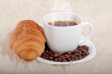 kruvasan ve fasulye kürk zemin üzerine kahve