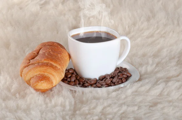 Rogalik z kawy i fasoli na tle futro — Zdjęcie stockowe