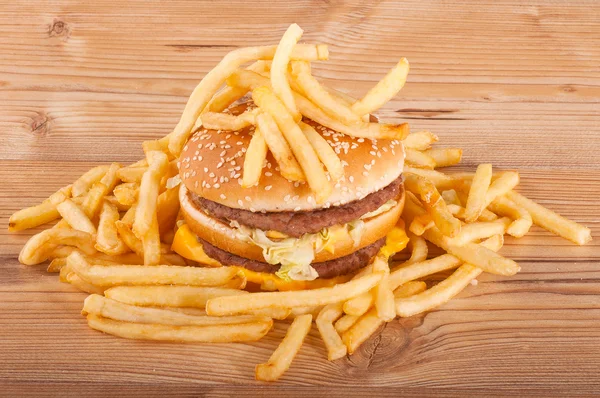 Hamburger et frites sur fond bois — Photo