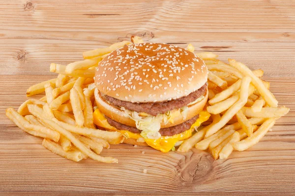 Hamburger and french fries on wooden background — Stock Photo, Image