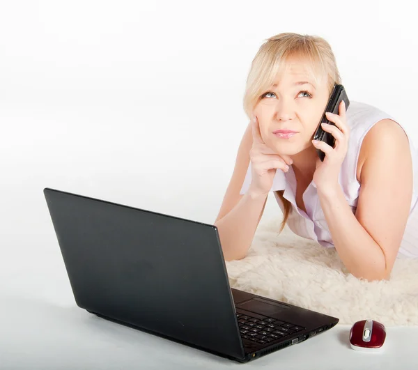 Mulher bonita com um laptop e telefone está em xadrez quente — Fotografia de Stock