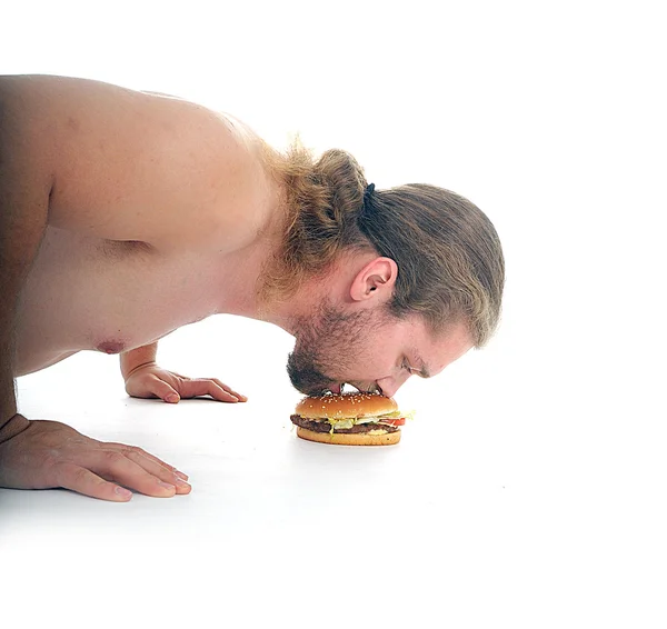 Uomo spinto dal pavimento e cercando di mangiare un hamburger — Foto Stock