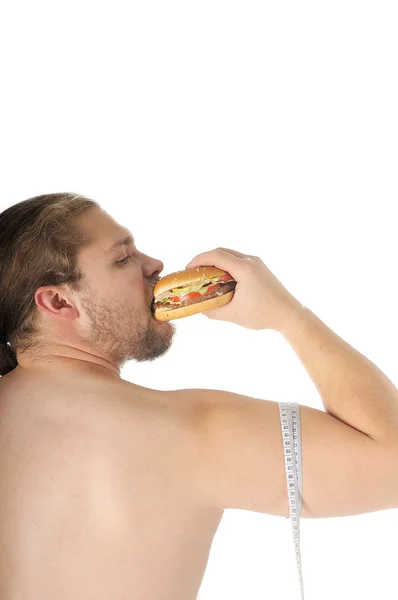 Hombre con hamburguesa y cinta métrica alrededor de bíceps sobre fondo blanco —  Fotos de Stock