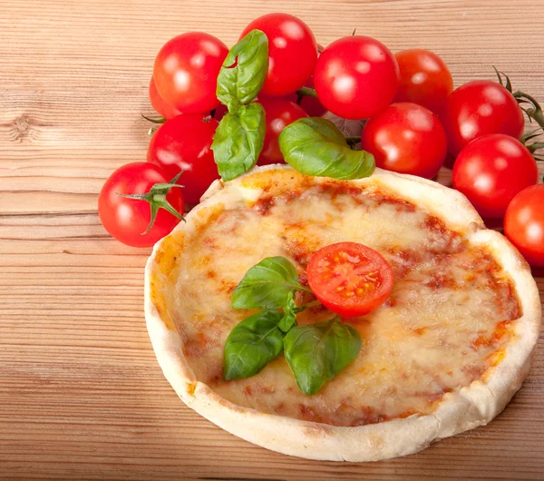 Close-up van pizza met tomaten, basilicum van de cheeseand op houten achtergrond — Stockfoto