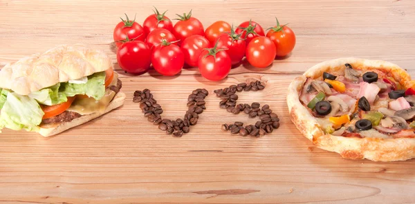 Tasty hamburger and pizza. vesrsus. vs. and some tomatoes — Stock Photo, Image