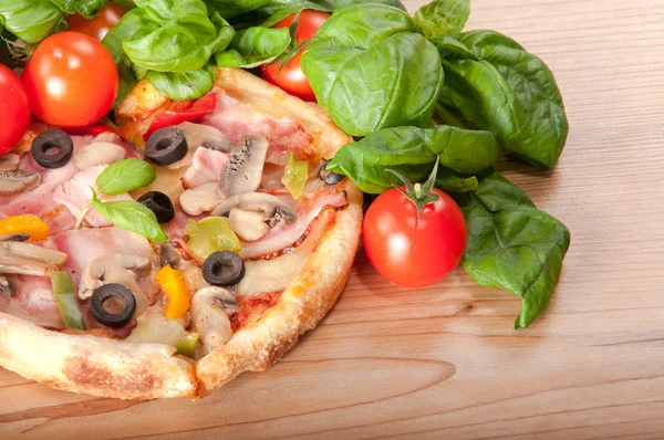 Close-up van pizza met tomaten, kaas en basilicum op houten achtergrond — Stockfoto