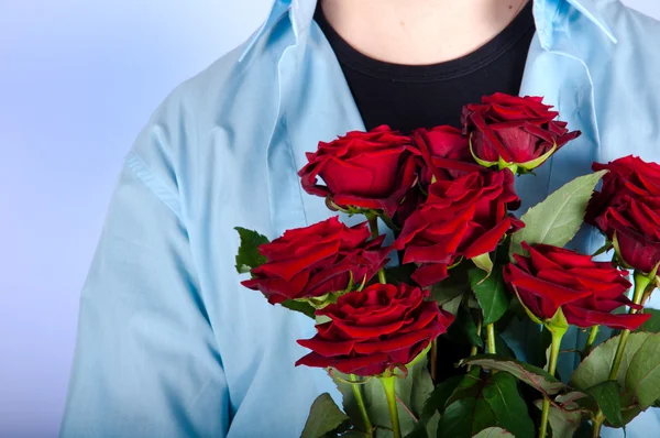 Schöner Mann mit einem Strauß roter Rosen — Stockfoto