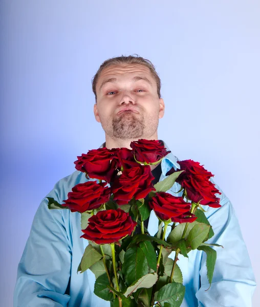 Bir demet kırmızı gül sunan yakışıklı adam — Stok fotoğraf