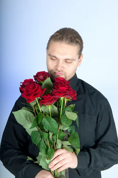 Handsome man offering you a bunch of red roses — Stock Photo, Image