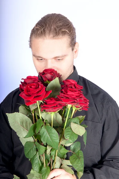 Hombre guapo ofreciéndote un ramo de rosas rojas — Foto de Stock